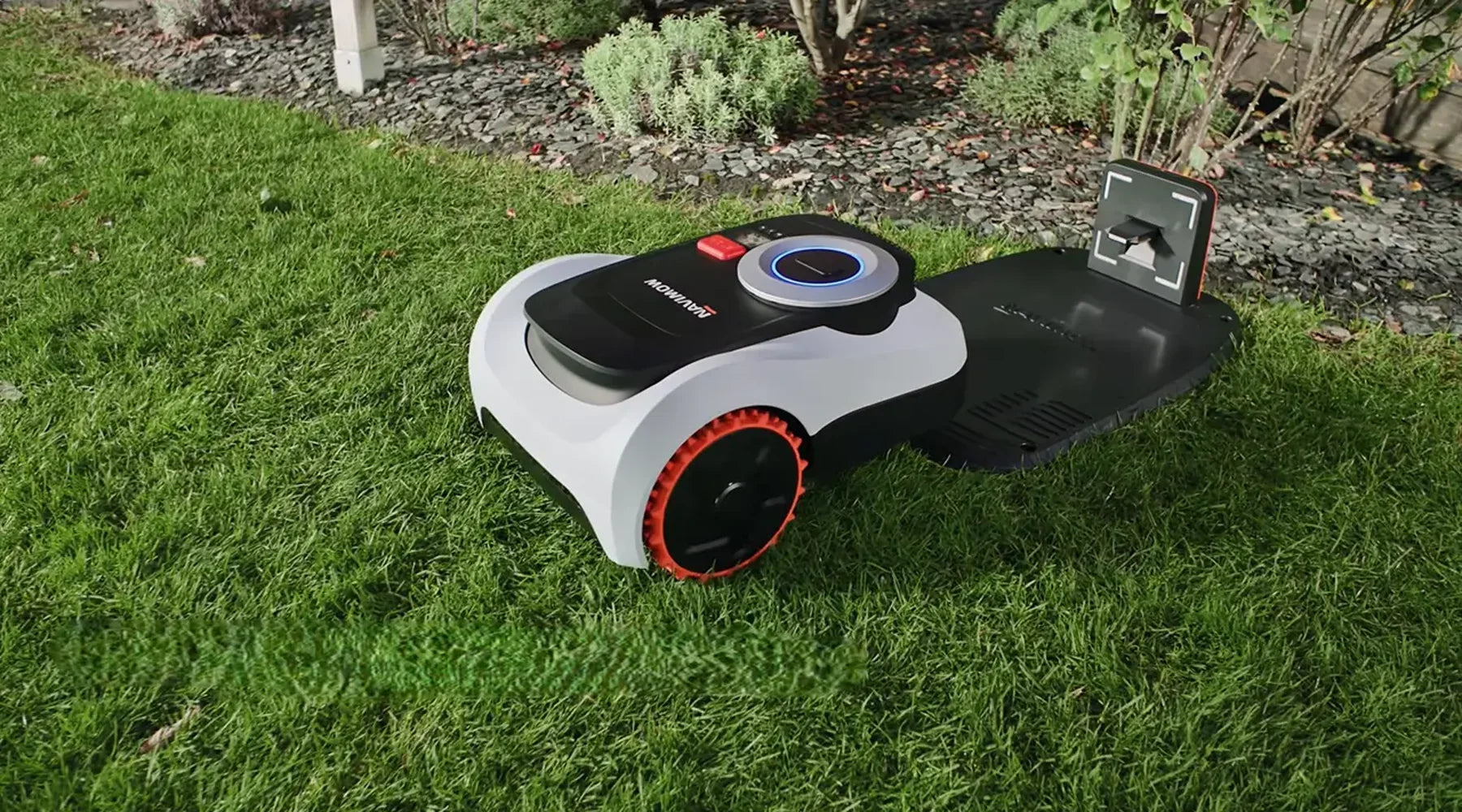 Een robotmaaier naast zijn laadstation in een Belgische tuin — themabeeld voor de gids over laadstationproblemen.