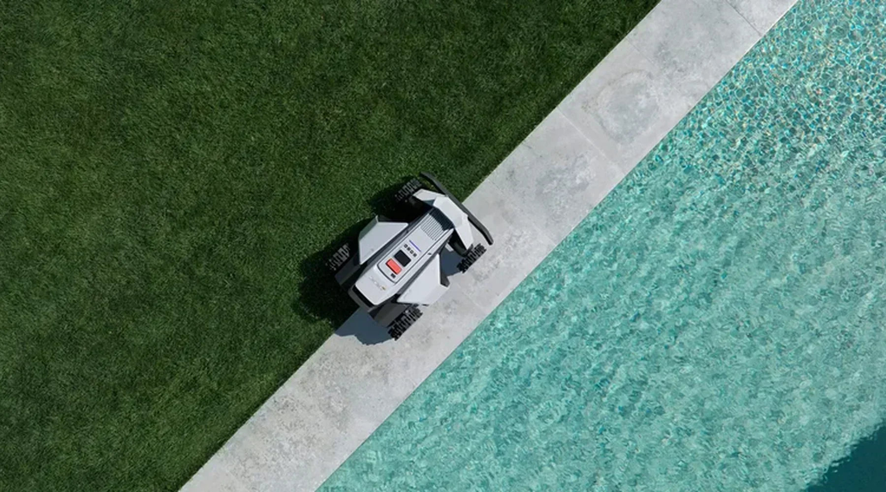 Bovenaanzicht van een NAVIMOW robotmaaier die precies langs de strakke rand tussen gazon en zwembadterras rijdt.