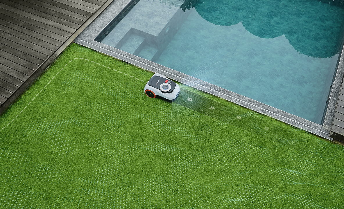 Segway Navimow i105E robotmaaier maait gras bij een modern zwembad.