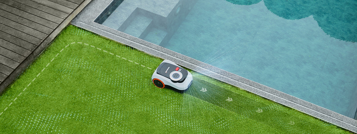 Navimow i105 robotmaaier maait het gras bij het blauwe zwembad.