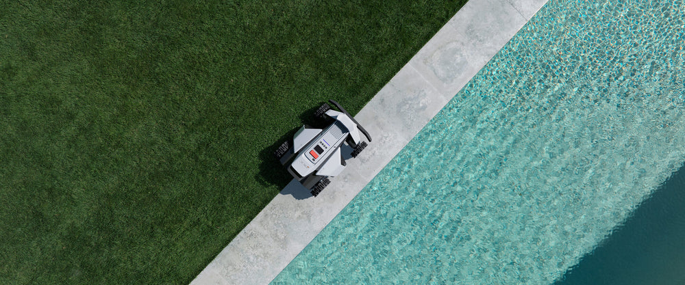 Navimow i110E robotmaaier op gras naast een helder blauw zwembad.