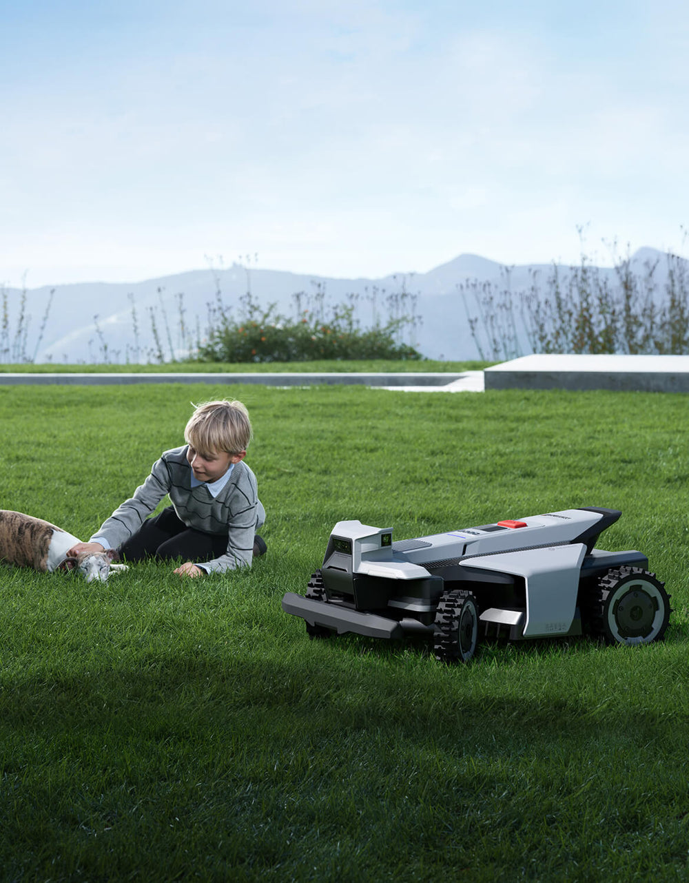 Segway Navimow i105E robotmaaier bij een jongen en zijn hondje.